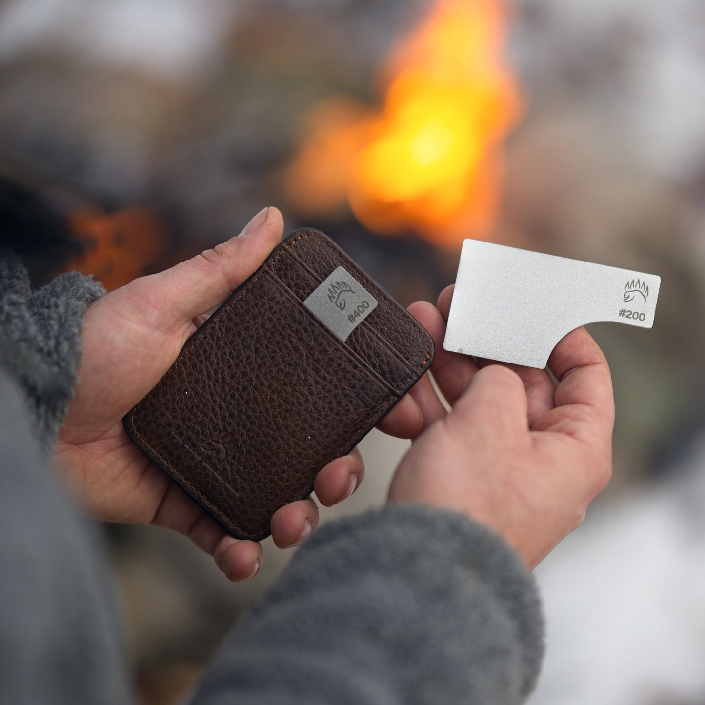 Premium Field Sharpener Wallet with #200 grit plate being removed from a leather wallet, ideal for outdoor knife sharpening by the fire.