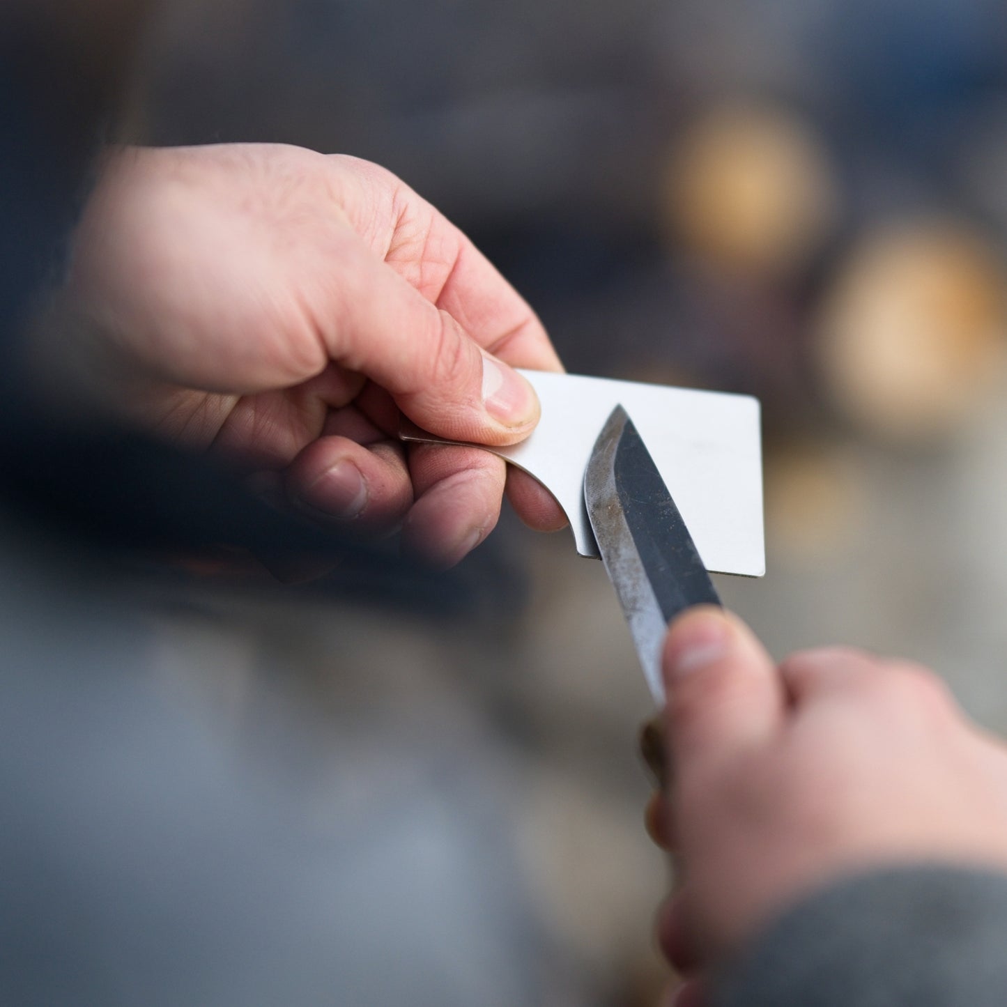 Sharpening a knife with the Field Sharpener Wallet's grit plate, demonstrating its practical use in outdoor environments.
