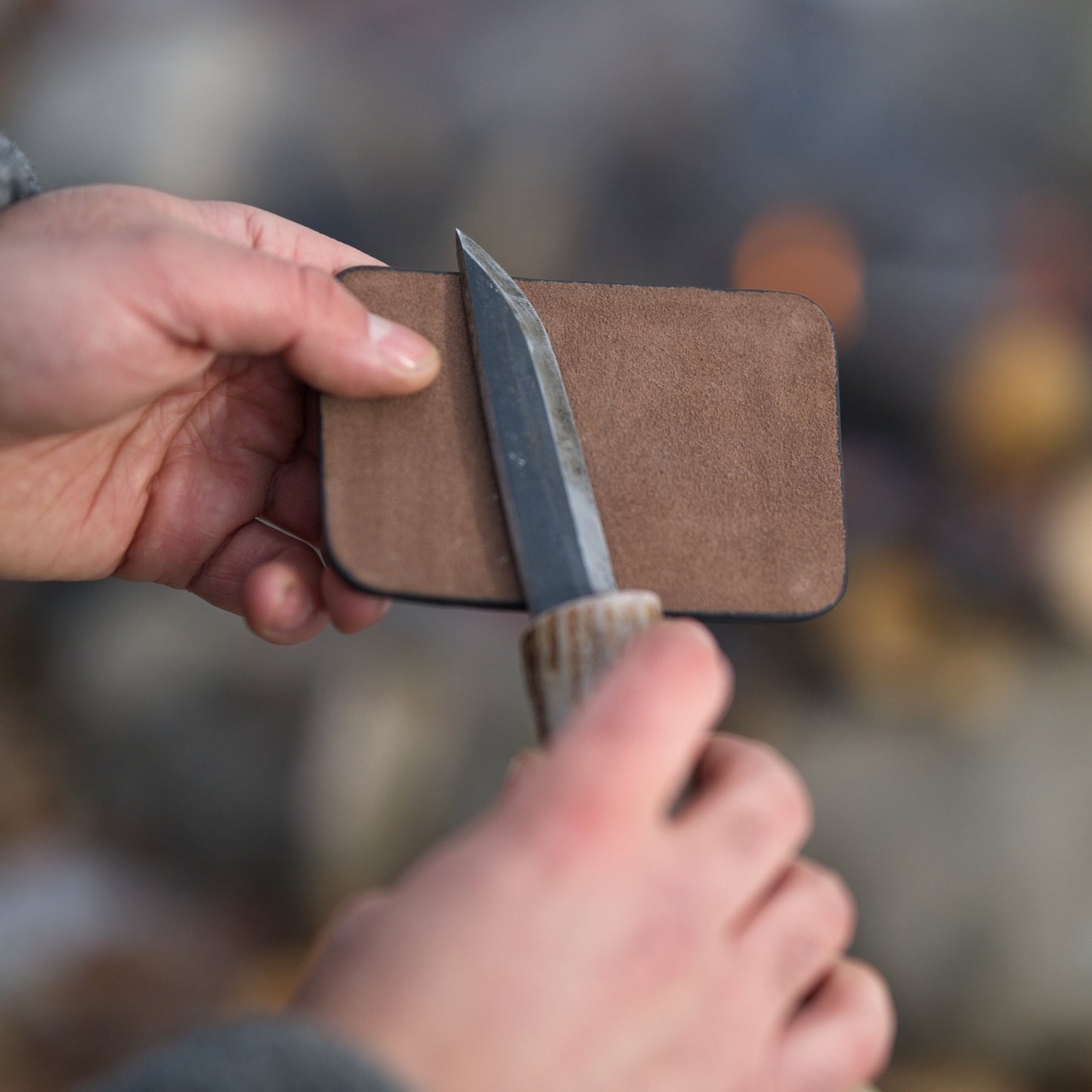 Using the leather strop side of the Field Sharpener Wallet to hone a knife blade. Combines sharpening and stropping in one tool.