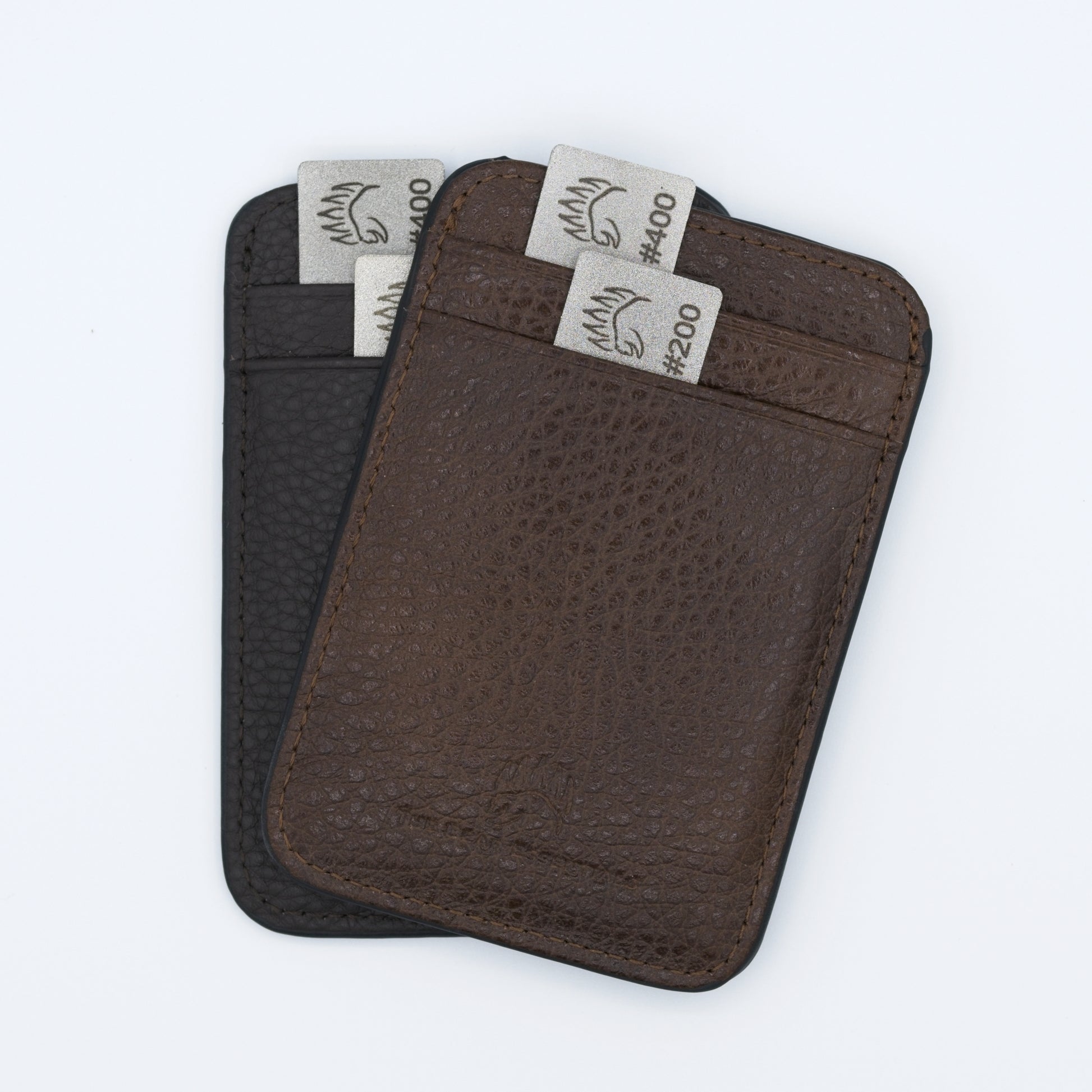 Two Field Sharpener Wallets in brown and black leather, each holding dual grit sharpening plates #200 and #400 for versatile blade maintenance.