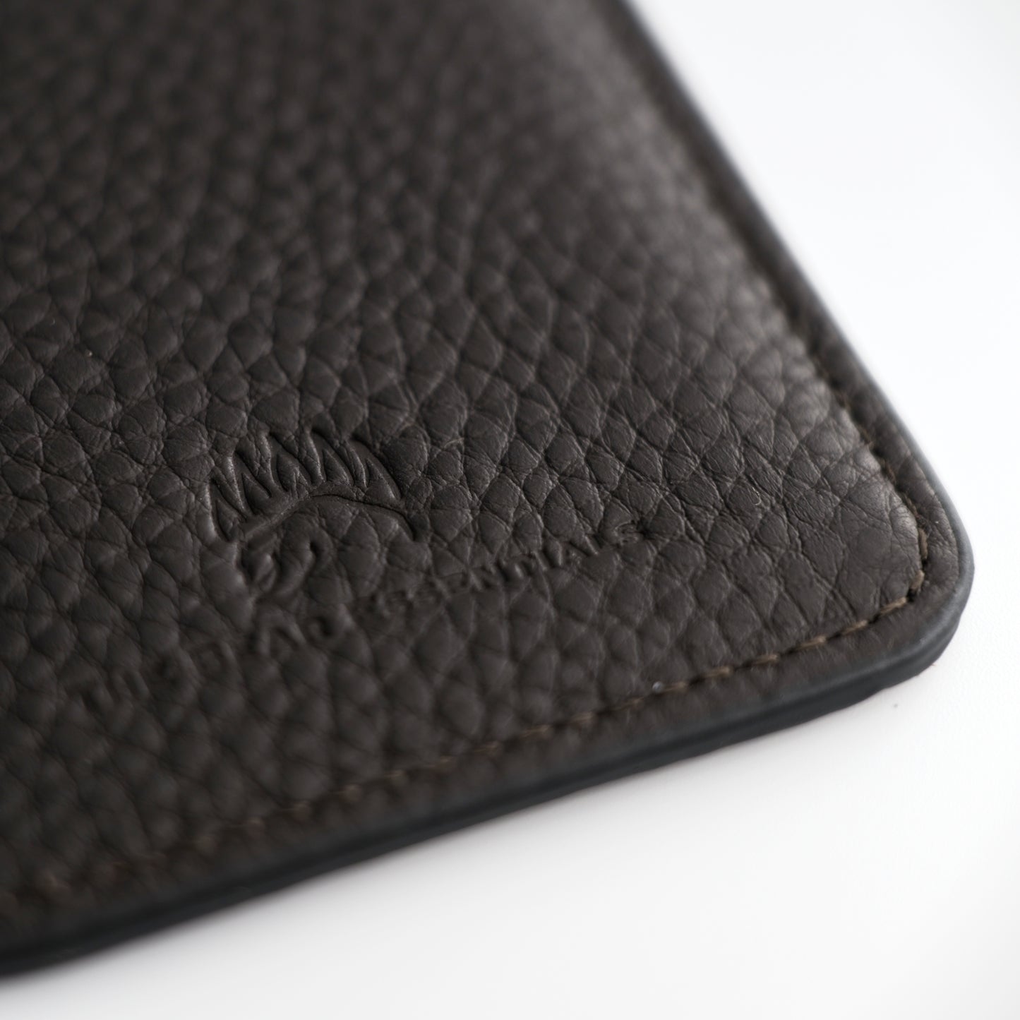 Close-up of the black leather Field Sharpener Wallet embossed with a bear logo, highlighting premium craftsmanship and texture.