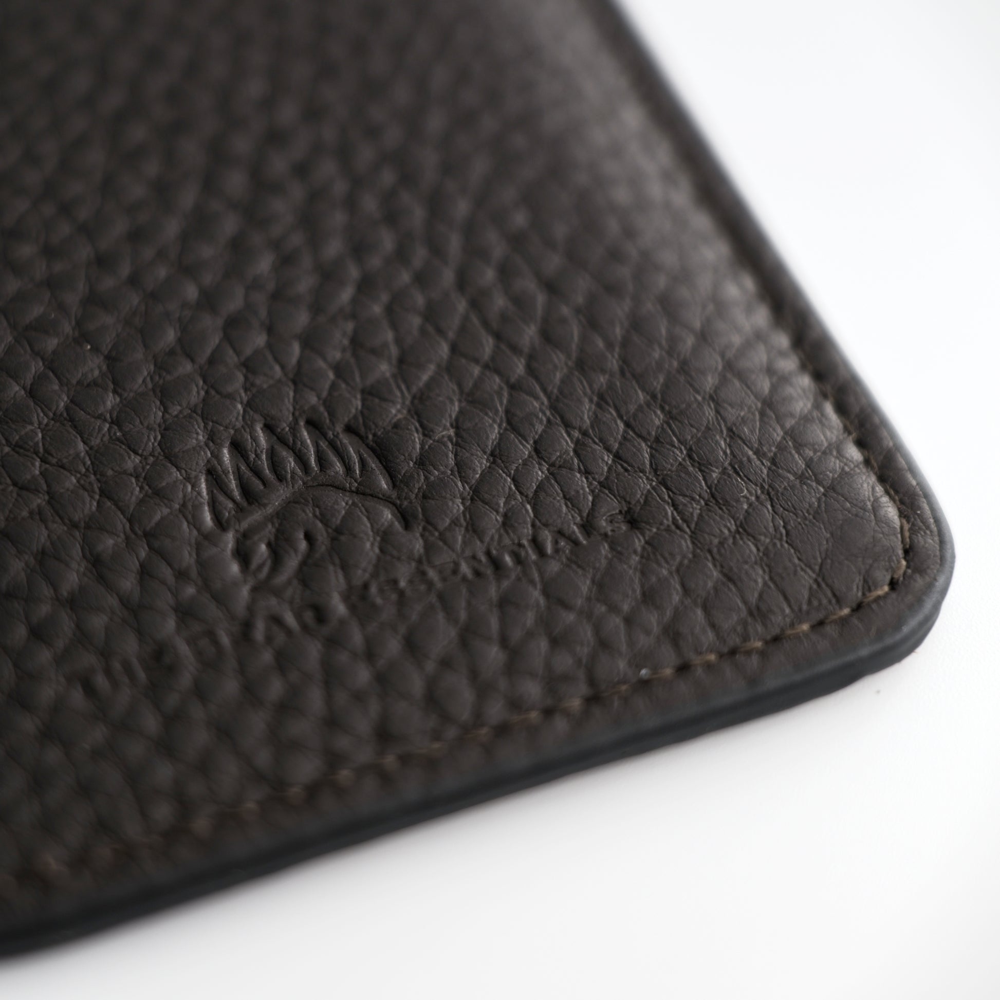 Close-up of the black leather Field Sharpener Wallet embossed with a bear logo, highlighting premium craftsmanship and texture.