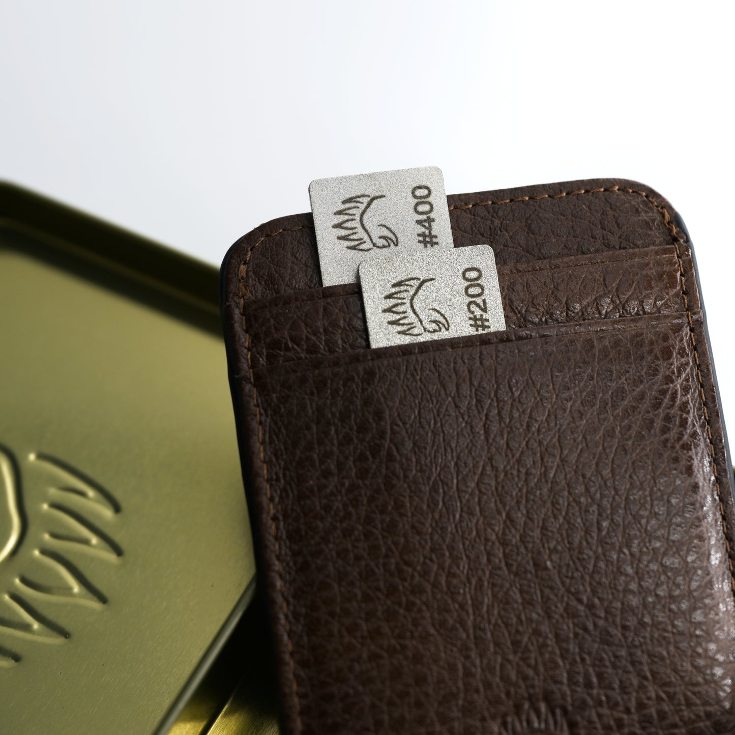 Field Sharpener Wallets with dual grit #200 and #400 sharpening plates stored in a brown handmade leather strop wallet. Compact and portable design.