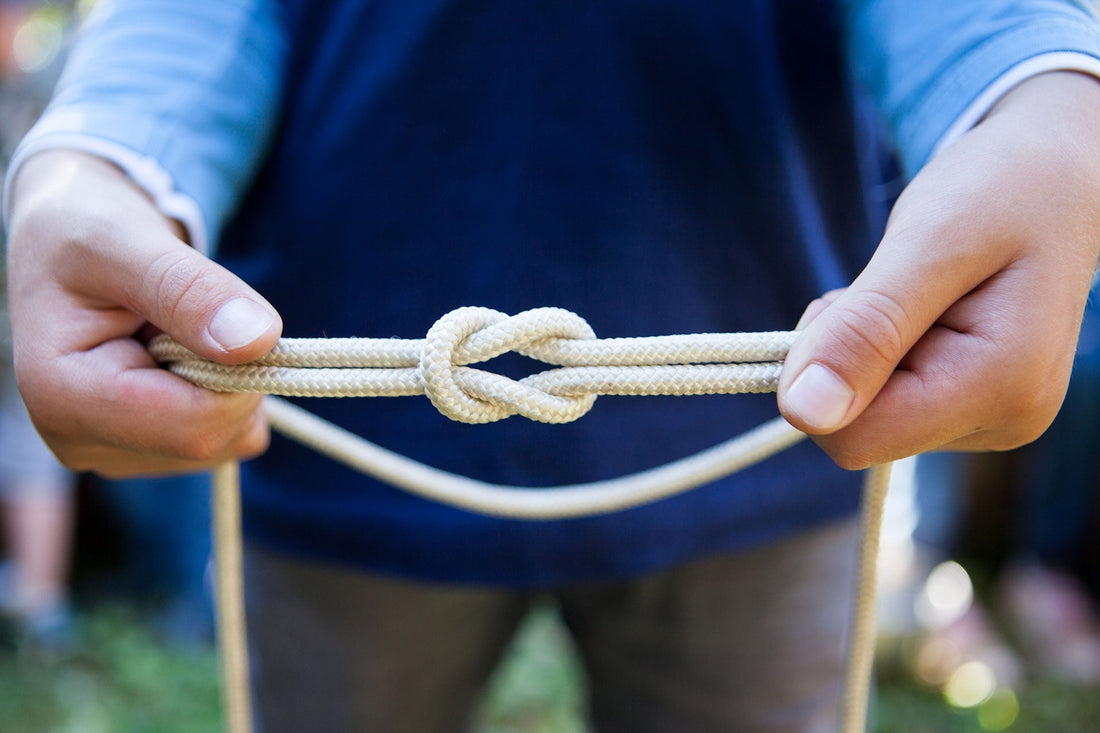 hands tying a knot with rope