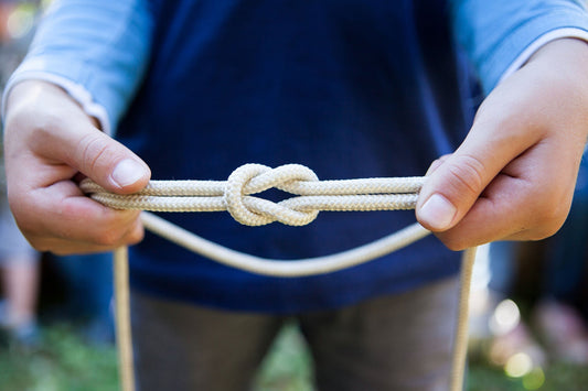 hands tying a knot with rope